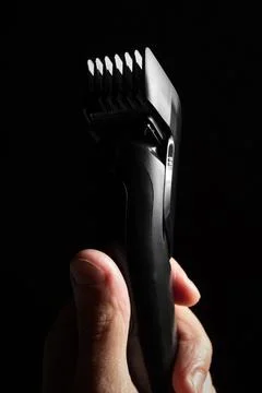 Close-up of Electric shaver machine with nozzle in hand on black background Stock Photos