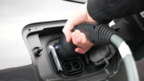 Close up of electric vehicle being plugged into a charge stop - Modern EV chargi Stock Footage 221134799