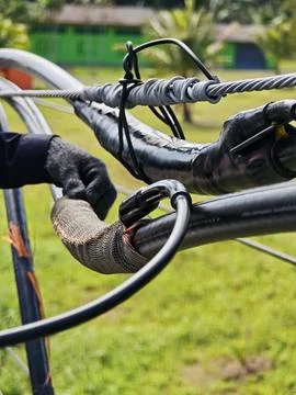 Close up of electrical lineman technician hands connecting copper wire shield. Stock Photos