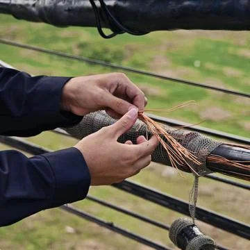 Close up of electrical lineman technician hands connecting copper. Stock Photos