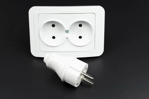 Close-up of electrical outlet, plug and light switch on black background Stock Photos