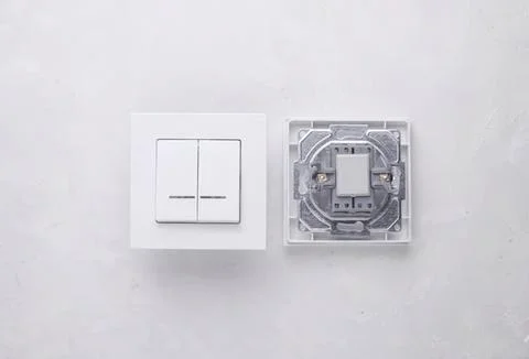Close-up of electrical switch and socket on white wall Stock Photos
