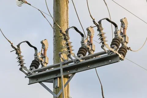 Close-up of electrical switchgear and insulators on wooden utility pole Stock Photos