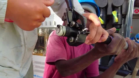 Close up of electrical technicians using a heavy-duty crimping tool on a thick Stock Footage 342467242