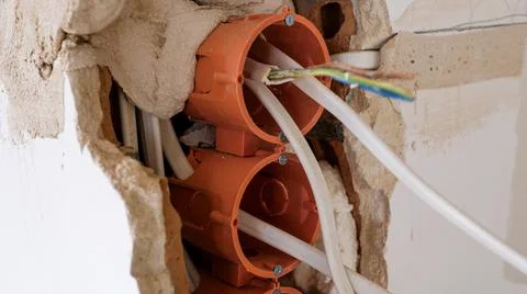 Close up of electrical wires hanging from a wall during apartment remodeling Stock Photos
