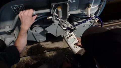 Close-up of an electrician checking the power supply wiring of a train's power Stock Footage 196357948