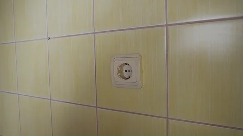Close-up of an electrician with a screwdriver seting up a white outlet. Видео 113062706