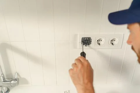 Close up of electrician using screwdriver while installing new electrical socket Stock Photos