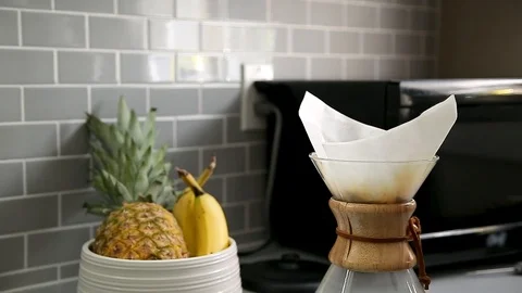 Close-up of a a electril kettle pouring hot water into a drip coffee flask with Stock Footage 115328774