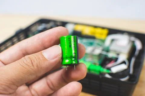 Close up of Electrolytic capacitor in hand isolated Stock Photos