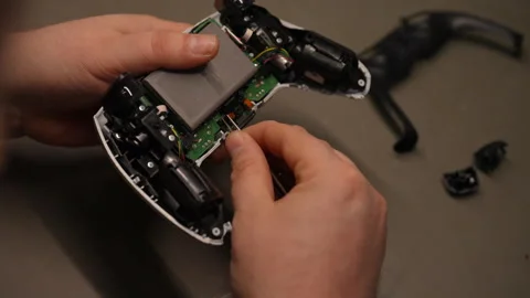 Close-up of electronic technician fixing damaged game controller, carefully Stock Footage 310624738