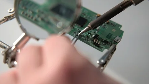 Close-up Electronics repair soldering microchips and circuit boards at computers Stock Footage 90049324