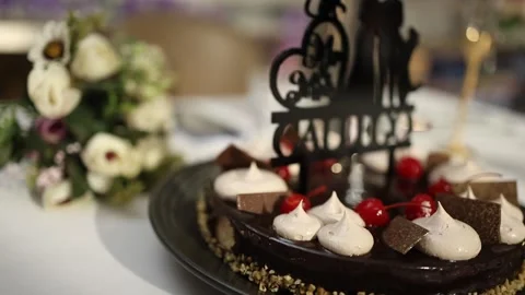 Close-Up of Elegant Chocolate Wedding Cake with Flowers and Personalized Topper Stock Footage 340560675