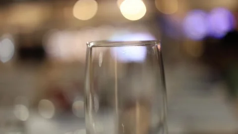 Close-up of Elegant Empty Wine Glass Against Bokeh Lights in Upscale Restaurant Stock Footage 340560639