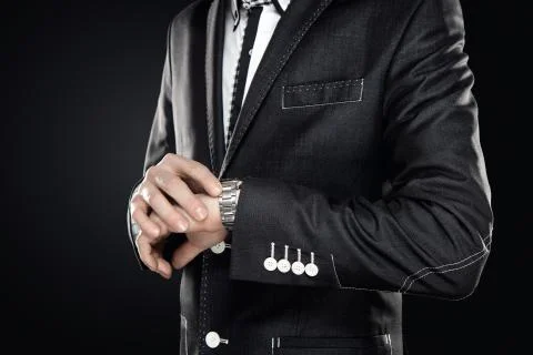 Close up of elegant man checking the time isolated on gray background Stock Photos