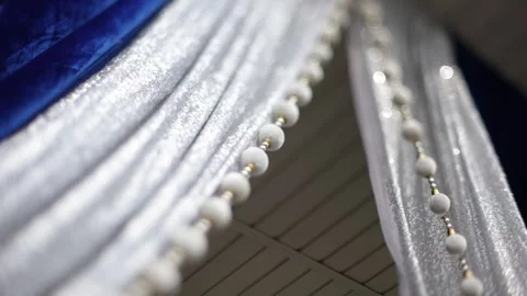 Close-up of elegant silver and blue curtains with decorative beads Stockbeeldmateriaal 316301723