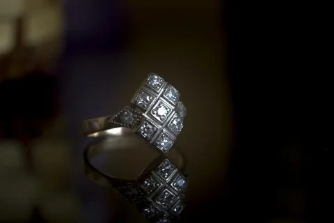 Close up of elegant silver designer ring isolated on dark black background. 3 Stock Photos