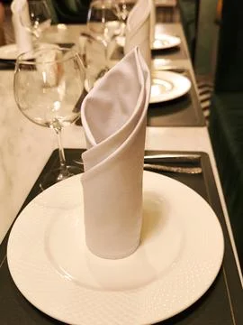 Close-up of an elegant table setting with a white napkin and a glass Stock Photos