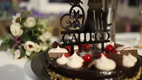 Close-Up of Elegant Wedding Cake with Custom Topper and Fresh Bouquet Stock Footage 340560671
