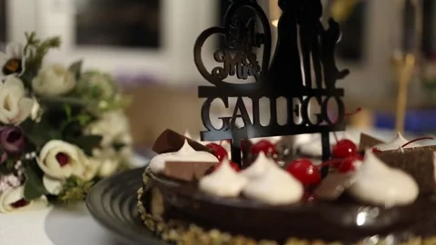 Close-up of Elegant Wedding Cake with Mr &amp; Mrs Gallego Topper and Flowers Stock Footage 340560618