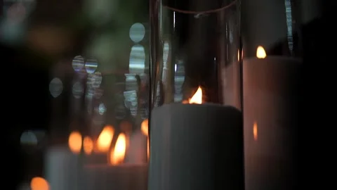 Close-up of elegant white pillar candles burning with soft flames in glass Stock Footage 345260187
