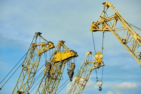 Close-up of elements of a yellow tower crane on a blue sky background. Foto stock