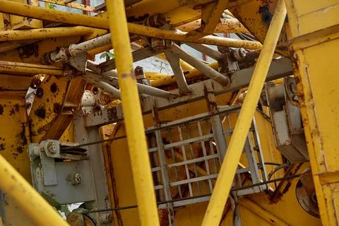 Close-up of elements of a yellow tower crane on a blue sky background. Foto stock