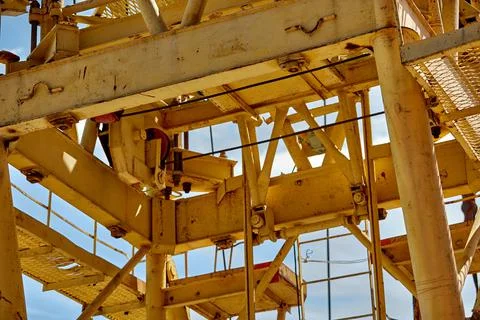 Close-up of elements of a yellow tower crane on a blue sky background. Stockfoto's
