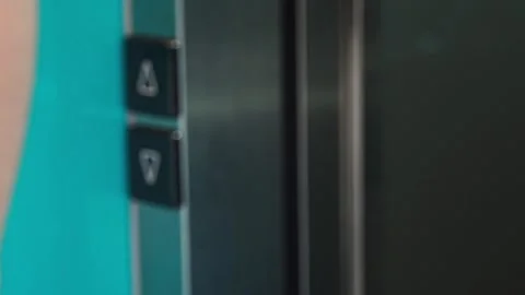 Close up of elevator call button as a person exits the lift. Everyday elevator Stock Footage 346396708