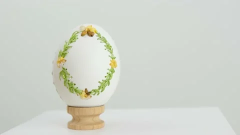 Close-up of an embroidered egg on the eggshell of goose eggs female hand slowly Vidéo 233970342