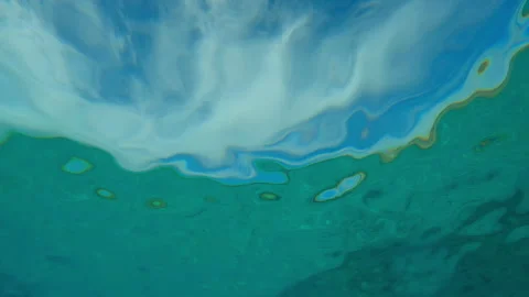 Close-up of emerald green water surface and blue sky with clouds during calm Stock Footage 336571145