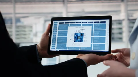 Close up of employee examining microchip circuit layout with tablet Stock Footage 335882421