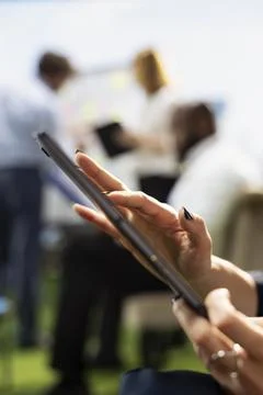 Close-up of employee hand typing on tablet screen during informal work Stock Photos