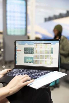 Close up of employee reviewing data reports on laptop in terminal lounge Stock Photos