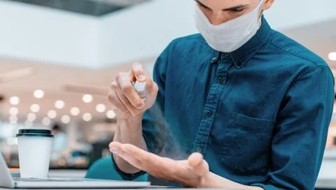 Close up. employee spraying antiseptic on his palm Stock Photos
