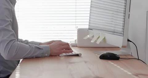 Close-up employee typing on keyboard in bright modern office workplace Stock Footage 140790461