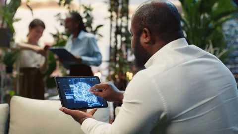 Close up of employee using tablet touchscreen to interact with AI assistant Video stock 345165114