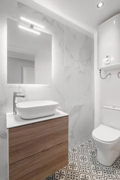 Close-up of an empty bathroom in white tones with a sink with a cabinet and a Stock Photos