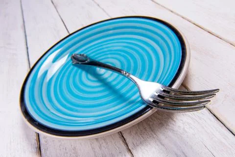 Close-up of empty blue ceramic plate, antique silver cutlery on vintage Stock Photos