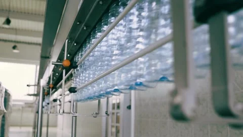 Close up of empty blue plastic bottles. Row of bottle in conveyer at water Video stock 334587979