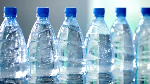 Close up of empty blue plastic bottles. Row of bottle in conveyer at water Video stock 334588403