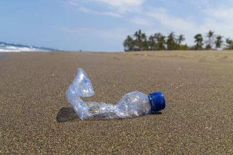 Close-up empty bottle plastic garbage on the sea beach. Stock Photos