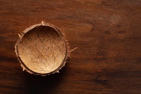 Close-up of empty coconut shell bowl over the wooden top background. Stock Photos