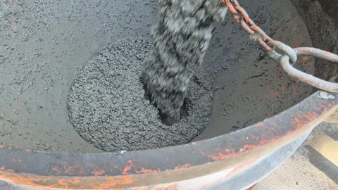Close-up of empty concrete bucket being filled with fresh liquid cement 動画素材 344030978