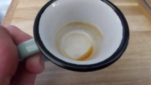 Close-up of an empty enamel coffee mug showing coffee stains on a wooden backgro Vídeo Stock 335826690