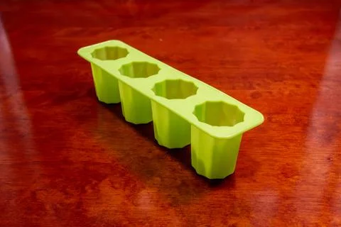 Close-up of empty green silicone four-cup fluted mold tray on wooden table Stock Photos