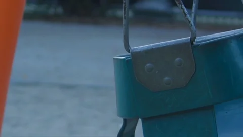 Close-up of empty moving bucket swing seat at playground Stock Footage 122183372