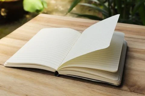 Close up of empty note book on wooden table during the day Stock Photos