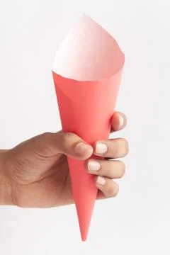 Close-up of empty pink white Paper cone bag holding in hand, for  snack packa Stock Photos