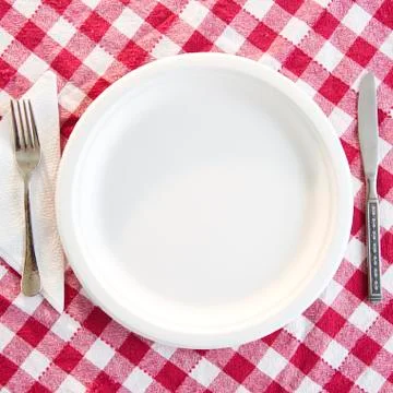 Close up empty plate on checked table cloth Stock Photos